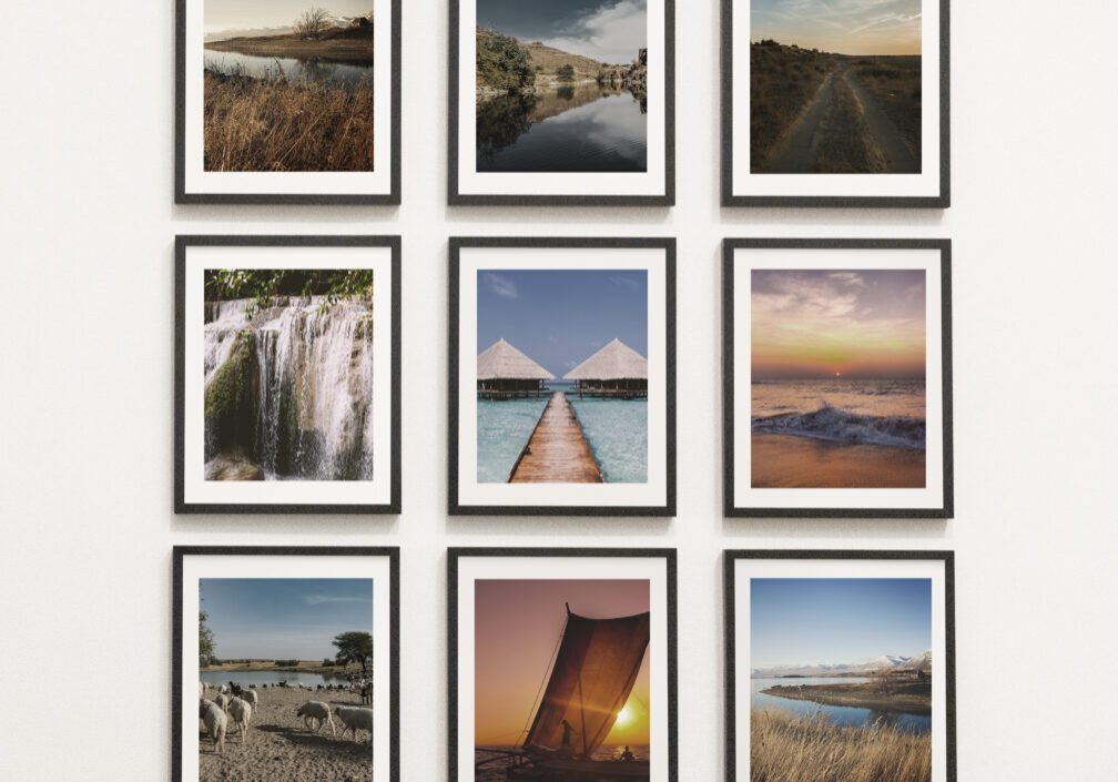 Nine framed landscape photos on white wall.